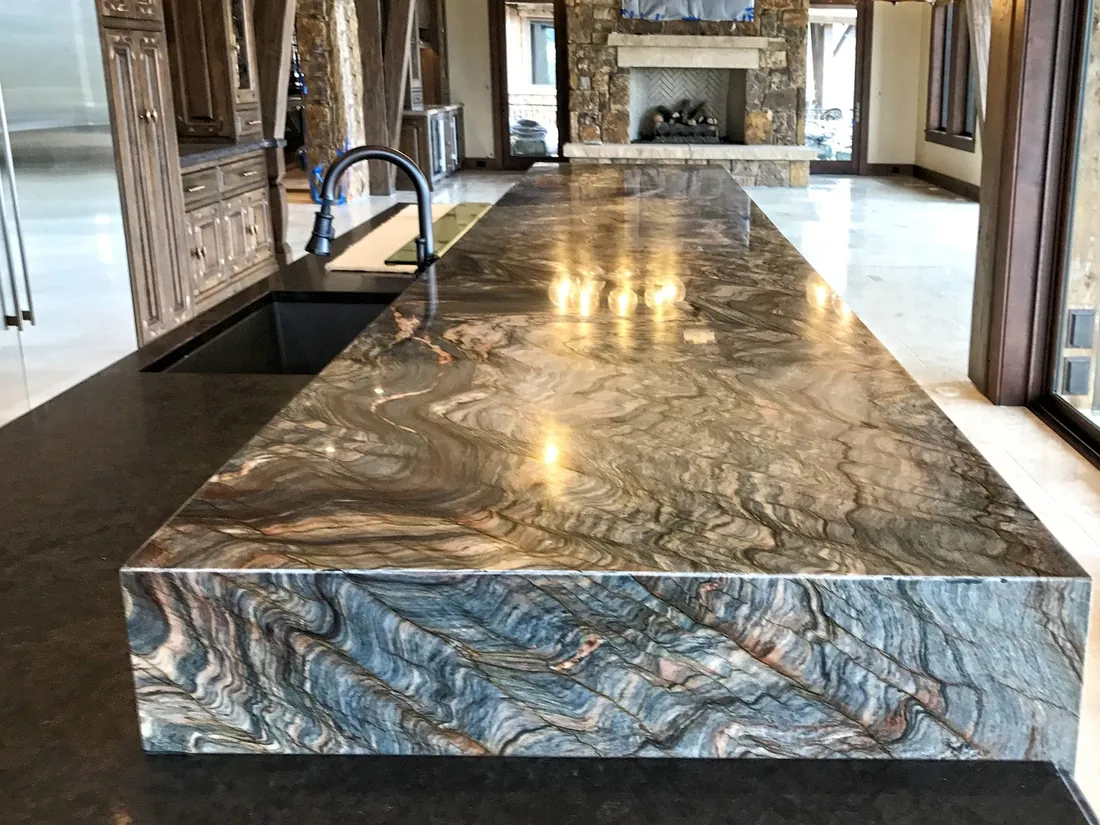 Stone kitchen counter with fireplace in the background