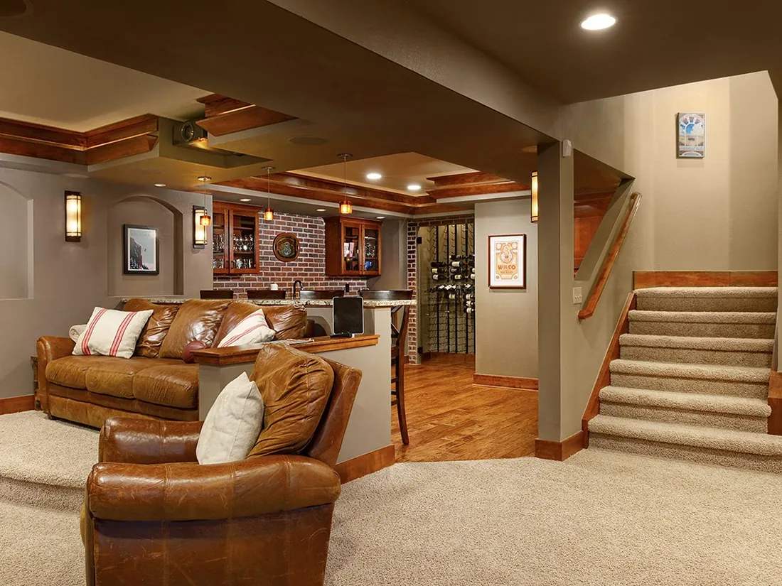 Finished basement with seating area and wet bar